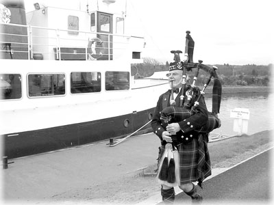 Scottish piper piping at the departure of the Jacobite Queen, Loch Ness.