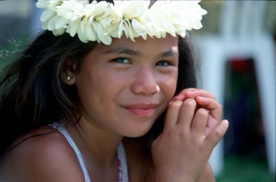 A young girl wearing a wreath of tiare flowers.