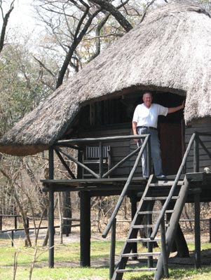 Fritz stands on the porch of his cabin at the Sikumi Tree Lodge in Dete.
