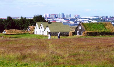Sod houses in Reykjavík with the modern city visible in the background.