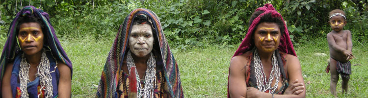 A Huli widow (center) with two relatives who will stay with her while she is in mourning. After her husband dies, a widow covers her body in white clay or ashes and wears many strands of "Job’s Tears," necklaces of seeds. Each week she removes some seeds, her mourning period ending with the last of them. 
