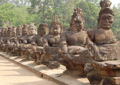 Stone guardians line a bridge at Angkor Thom.