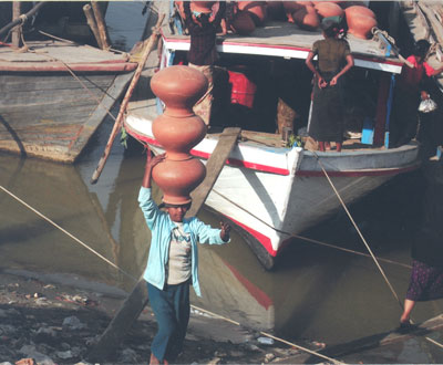 Women unloading clay pots from a boat on the Ayerwaddy River — Myanmar. Photos: Lin