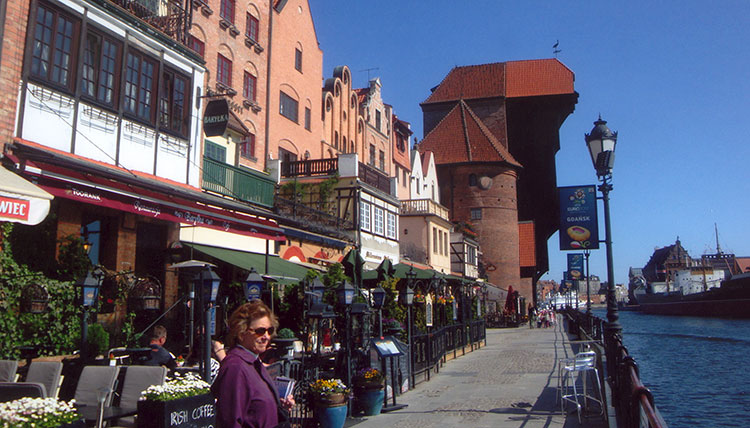 Giant medieval crane and Hanseatic buildings along the Motlawa River in Gdańsk.