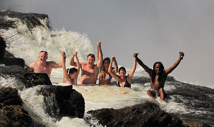 Members of the Gianini family brave the cold, rough waters at the edge of Victoria Falls.