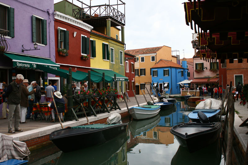 A canal winds past the brightly colored buildings of Burano.
