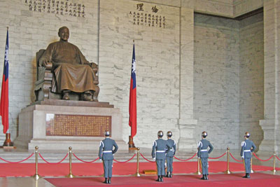 Soldiers standing in front of a statue of Chiang Kai-shek in his memorial hall.