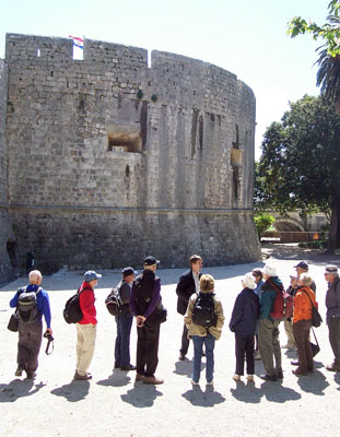 An ElderTreks guide sharing the history of Dubrovnik with his tour group outside a wall of the Old City. Photo by Randy Keck