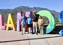 This sign sits atop Mount Alamos. Left to right: Tom and Lynn Meadows and friends Vince and Susan.
