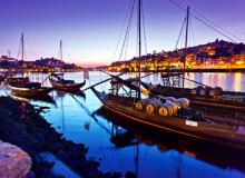 Traditional “rabelo” boats, which were once used to deliver port wine from the Douro Valley, line Porto’s harbor at sunset.