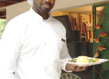 Chef Dwayne of <b><i>Ciao Jamaica</i></b> with a plate of Jamaican Goat Curry — Negril. Photos by Sandra Scott