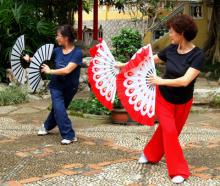 Two women performed morning exercises in the courtyard of Lou Lim Iok Garden.