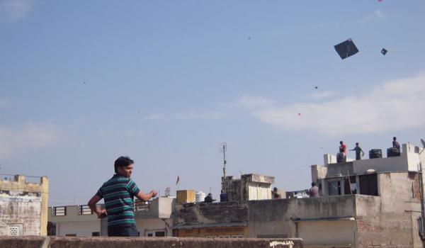 Boys and men take to the rooftops to fly their kites — Jaipur.