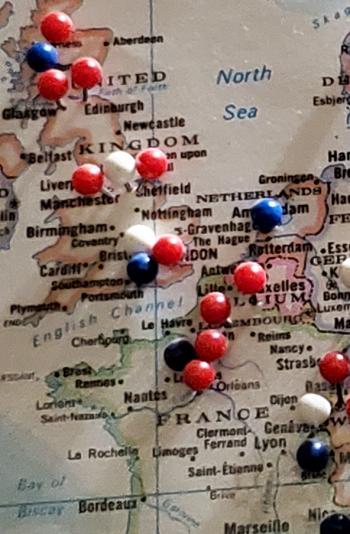 On this world map, red, blue and white stickpins represent travelers.