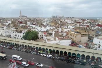 Casablanca's medina in the foreground, with the Hassan II Mosque and modern buildings in the background.