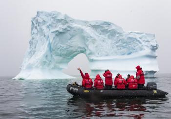 A Zodiac takes passengers out to observe the surrounding icebergs.