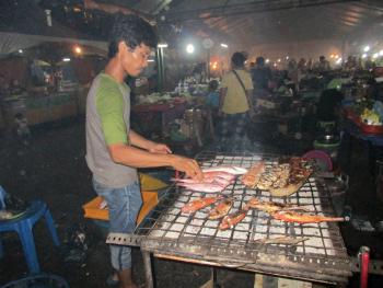 A vendor barbecues fish at Kota Kinabalu’s night market.