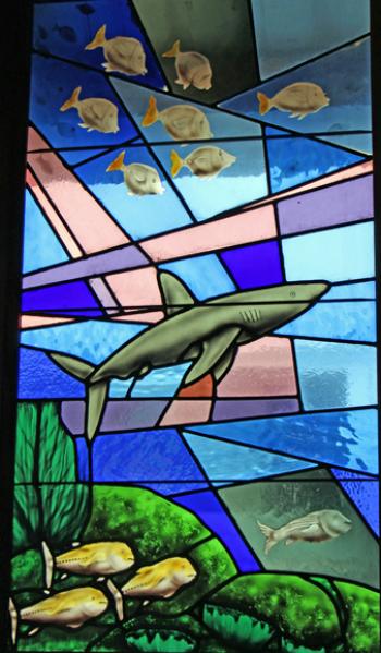 Stained-glass window depicting a shark and other fishes.