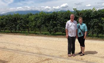 Norman and Susan Dailey at DCOG Winery, with the Dolomite Mountains showing just over the vine tops. Photo by guide Simona