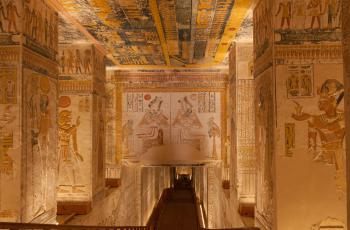 The colorful and elaborately carved pillared hall inside the tomb of Ramses V and Ramses VI (KV9), with the ceiling showing the head and arms of the Goddess Nut above the end of the Book of the Day and the beginning of the Book of the Night.