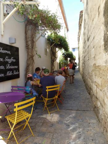 Travelers stop for a break on a side-street café in the town of Aigues-Mortes.