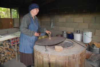 A woman baking bread in her toné oven.