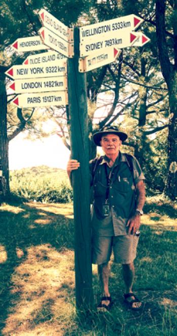 Jim Hamel at the signpost at the highest point of Pitcairn Island.