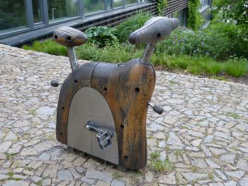 In the Open Gardens' Playful Garden, a stationary bicycle helps teach visitors about the generation of wind — Brno, Czechia.