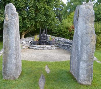 A path through limestone pillars leads to a wooden throne in the Beltaine garden of Brigit's Garden — County Galway, Ireland. 