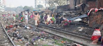 Trains run all day through the Dhaka slums.