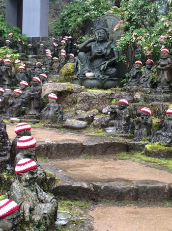 The path leading to Daisho-in, lined with Jizo Bosatsu statues, each waearing a red-and-white crocheted cap.