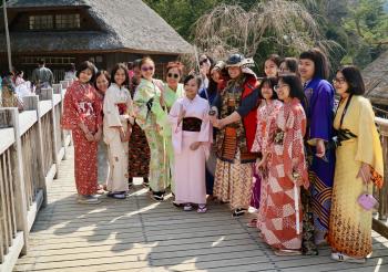 Visitors in rented traditional dress — Iyashi no Sato Open Air Museum.