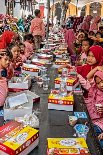 A village visit in Indonesia offered a chance to interact with local children enjoying a prepared lunch.