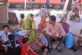 Family in a train station in New Delhi, India. Photo by Rob Sangster