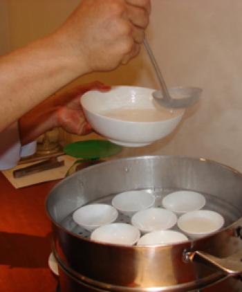 Ladling the flour mix into the molds for steaming.