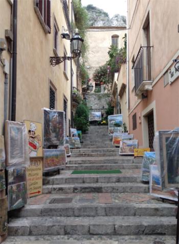 Artists' works displayed on a narrow lane running up a hill from the main pedestrian promenade in Taormina. Photo by Fred Steinberg