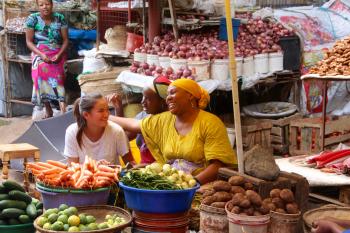 Our granddaughter, PJ, and a vegetable vendor at a market in Arusha.