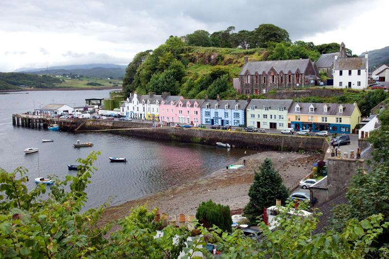 Portree, the largest town on the Isle of Skye, is nestled deep in its protective harbor, where colorful homes look out over bobbing boats and the surrounding peninsulas. Photo by Dominic Arizona Bonuccelli