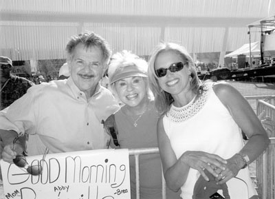 Norm and Mary Helber pose with Katie Couric at the Olympic Village.