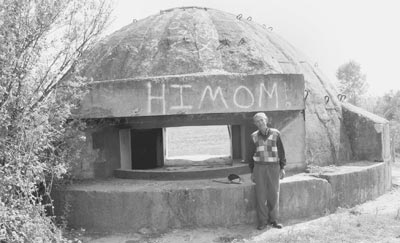 A typical concrete pillbox in Albania. The pictured local resident stables his donkeys inside.