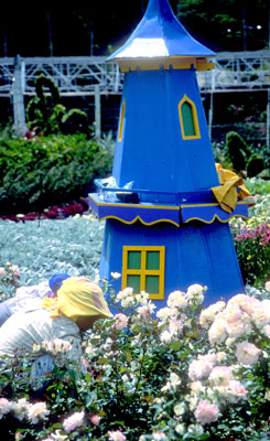 Workers tend gardens accented by miniature buildings at the fairgrounds — Boquete.