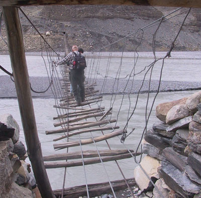 A member of our tour group tackling a bridge across the Hunza River in Pakistan. 