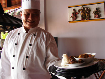 Myint Soe, Executive Chef at Amazing Ngapali Resort, with curries on a lacquerware platter. 