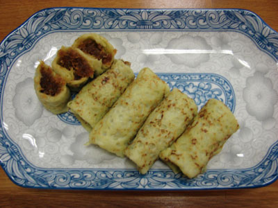 Kueh Dadar on a plate decorated with a typical Peranakan design.