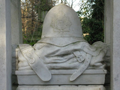 A grave featuring a bobby’s hat in Abney Park Cemetery — London. Photo by JoAnn Irwin