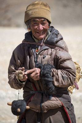 A Tibetan man making a spool of wool from yak hair — China. Photo ©piccaya/123rf.com 