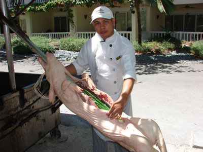 Chef Joseph at the head of the cooked, carved pig.