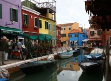 A canal winds past the brightly colored buildings of Burano.