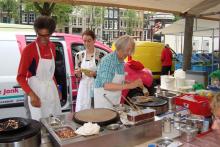 Women making pancakes in the farmers’ market — Amsterdam. Photo: Hill