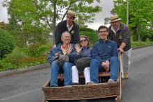 Stan Kimer (left) and two British friends riding the toboggan down the hill into Funchal.